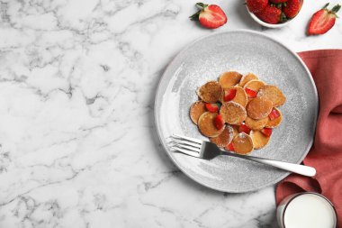 Beyaz mermer masada servis edilen çilekli leziz mini krep gevreği. Metin için boşluk