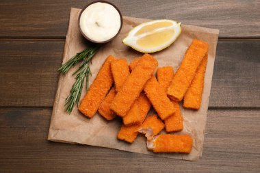 Tahta masada servis edilen taze ekmek, balık kroket, sos ve limon.