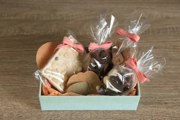 Tahta masada çikolatalı ve şekerli bir hediye kutusu.