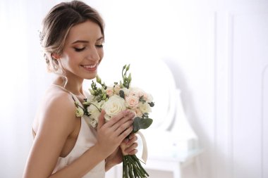 Odada güzel bir düğün buketi olan genç gelin. Metin için boşluk