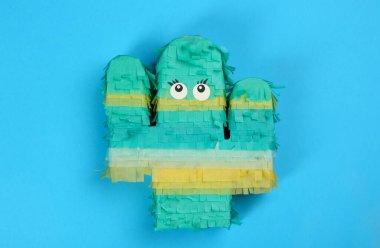 Açık mavi arkaplanda parlak kaktüs pinyatası, üst görünüm