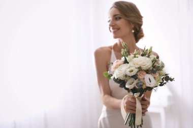 Odada güzel bir düğün buketi olan genç gelin, çiçeklere odaklan. Metin için boşluk