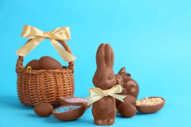 Açık mavi arka planda çikolatalı Paskalya tavşanları ve yumurtalar.