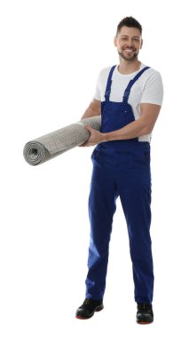 Beyaz arka planda rulo halı olan erkek işçi.