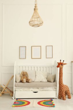 Bebek odasının içinde beşik ve oyuncaklar var.