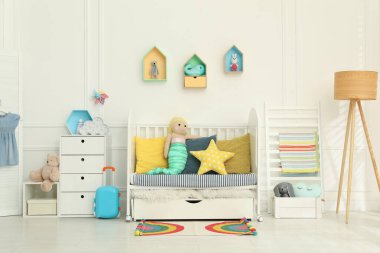 Bebek odasının içinde beşik ve oyuncaklar var.