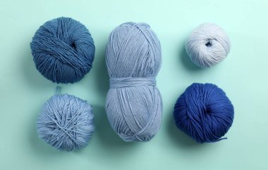 Açık mavi arkaplanda yumuşak yün iplikler, düz uzanmış