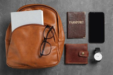 Şık şehir sırt çantası ve siyah masa üzerinde farklı öğeler, düz yatıyordu