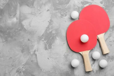 Ping pong rackets and balls on grey table, flat lay. space for text