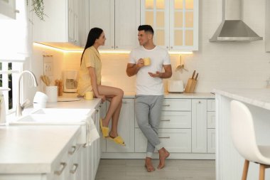 Pijama giyen ve mutfakta birlikte vakit geçiren mutlu bir çift.