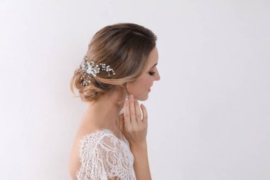 Açık arkaplanda zarif düğün saç stili olan genç gelin. Metin için boşluk