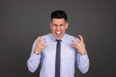 Koyu gri arka planda duygusal iş adamının portresi. Kişilik kavramı