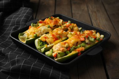 Doldurulmuş kabaklı fırın tabağı ahşap masada servis edilir, yakın plan.