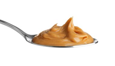 Beyaz kaşık içinde lezzetli fıstık ezmesi.