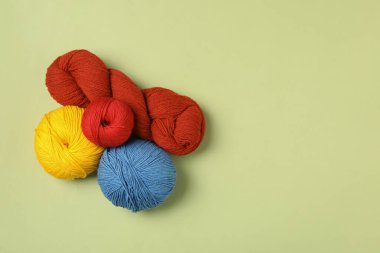 Yeşil arka planda yumuşak yün iplikler, düz yatış. Metin için boşluk