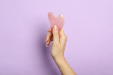 Leylak arkaplan üzerinde gül kuvars sha aracı ile kadın, yakın plan