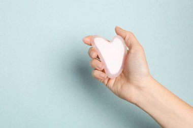 Işıklı arka planda gül kuvarsı olan kadın, yakın plan. Metin için boşluk