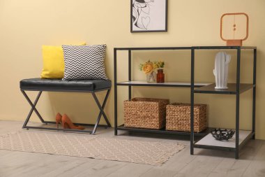 Koridordaki bej duvarın yanında dekor ve bank olan konsol masası. İç tasarım