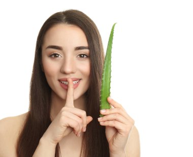 Beyaz arka planda aloe vera yaprağı olan genç bir kadın.