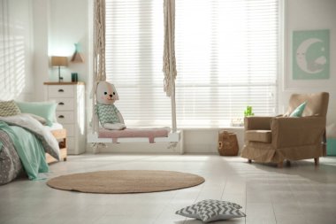 Çocuk odasında oyuncakla şık bir salıncak. İç tasarım