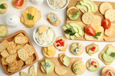 Beyaz ahşap masada tuzlanmış krakerler ve düz bir masa.