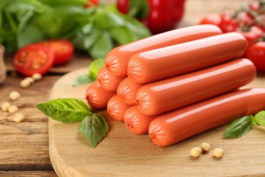 Taze çiğ vejetaryen sosisi, fesleğen ve soya fasulyesi ahşap masada, yakın plan.