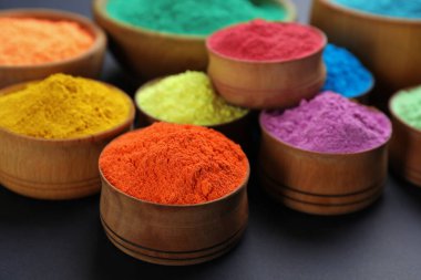 Siyah arka planda ahşap kaselerde renkli tozlar. Holi festivali kutlaması