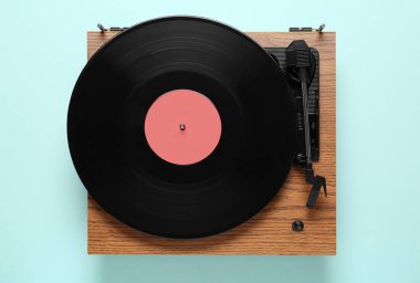 Açık mavi arkaplanlı vinil plaklı modern turntable, üst görünüm