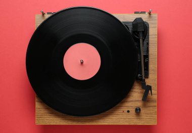 Kırmızı arka planda vinil plaklı modern turntable, üst görünüm