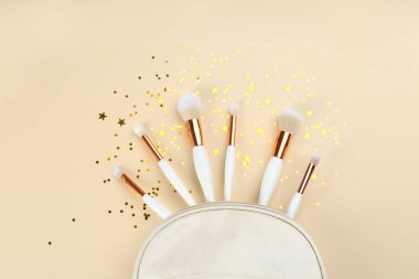 Bej arkaplanda makyaj fırçaları olan düz konum