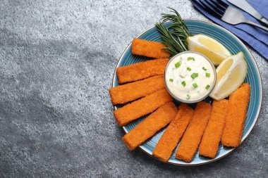 Taze ekilmiş balık kroket, sos ve limon gri masada servis edilir. Metin için boşluk