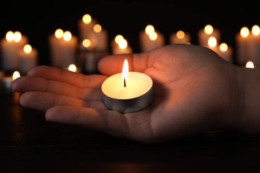 Karanlıkta yanan mumu olan kadın, yaklaş. Hafıza Günü