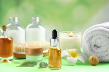 Yeşil masadaki spa kozmetik ve plumeria çiçekli kompozisyon