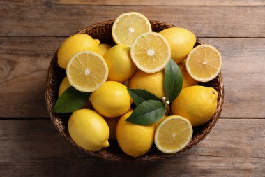 Tahta masanın üzerinde taze limonlar var.