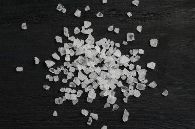 Natural sea salt on black table, flat lay clipart