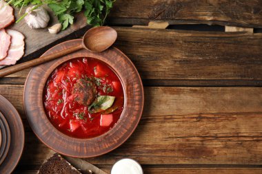 Ahşap masa üzerinde servis edilen Ukrayna borsch ile süslü kahverengi kil levha düz yatıyordu. Metin için boşluk