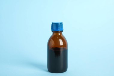 Açık mavi arka planda bir şişe tıbbi iyot.