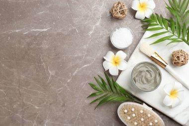 Gri arka planda kozmetik ürünü olan düz kompozisyon, metin için boşluk. Kaplıca gövdesi sargıları