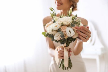 Odada güzel bir düğün buketi olan genç gelin, çiçeklere odaklan. Metin için boşluk