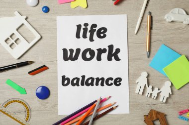 Düz kompozisyon, kağıt çarşaf ve açık ahşap masa. Yaşam iş dengesi kavramı