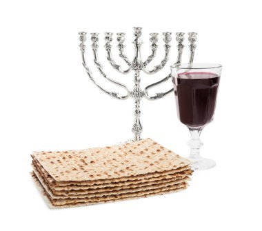 Geleneksel matzos, kırmızı şarap ve beyaz arka planda menorah.