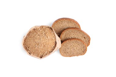 Kağıt torba içinde taze ekmek kırıntıları ve beyaz arka planda bir dilim ekmek, üst manzara.