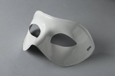 Gri arkaplanda beyaz tiyatro maskesi, yakın plan.