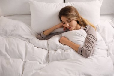 Sıcak beyaz battaniyenin altındaki kadın evin içinde, manzaranın üstünde uyuyor. Metin için boşluk