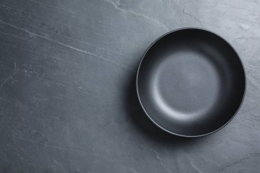 Gri masadaki boş seramik kâse, üst manzara. Metin için boşluk