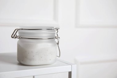 Beyaz masada bir kavanoz tuz fırçası. Metin için boşluk