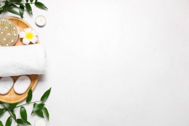 Beyaz masadaki spa ürünlerinin olduğu düz bir kompozisyon. Metin için boşluk