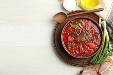 Ukrayna borsch 'u ile süslü kahverengi kil kase beyaz ahşap masada, düz yerde servis edilir. Metin için boşluk