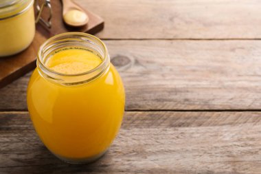 Ahşap masada cam kavanoz Ghee yağı. Metin için boşluk