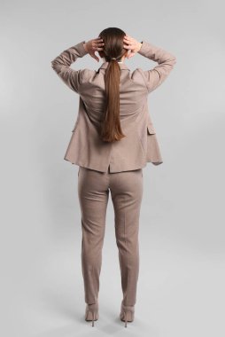 Gri arka planda genç bir kadın.